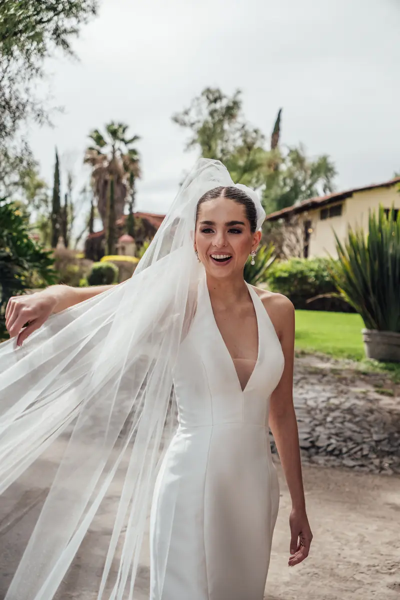 Novia con el velo al aire en el jardín de Hacienda La Magdalena