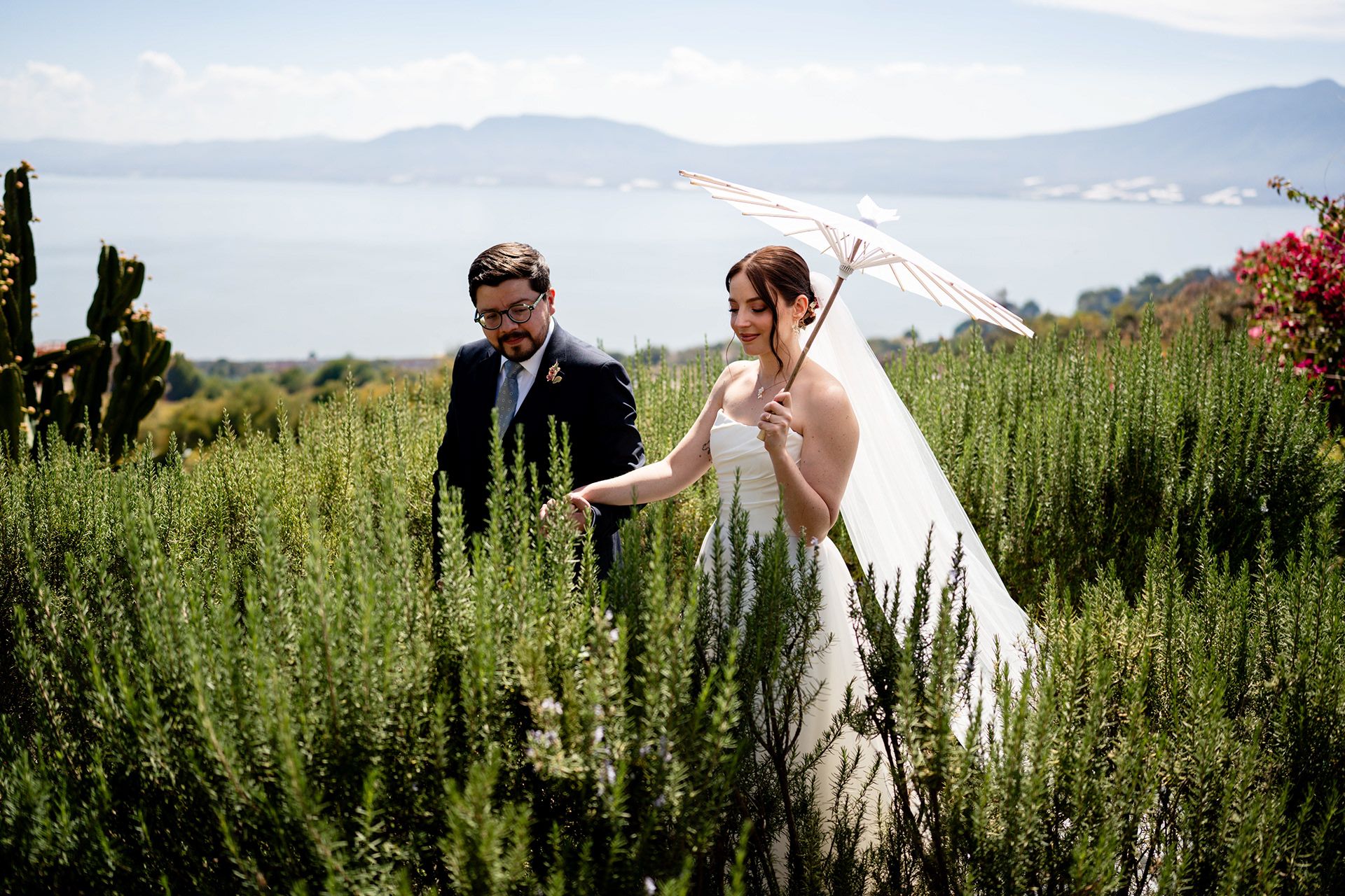 Bride and groom walking through gardens above Lake Chapala, Jalisco