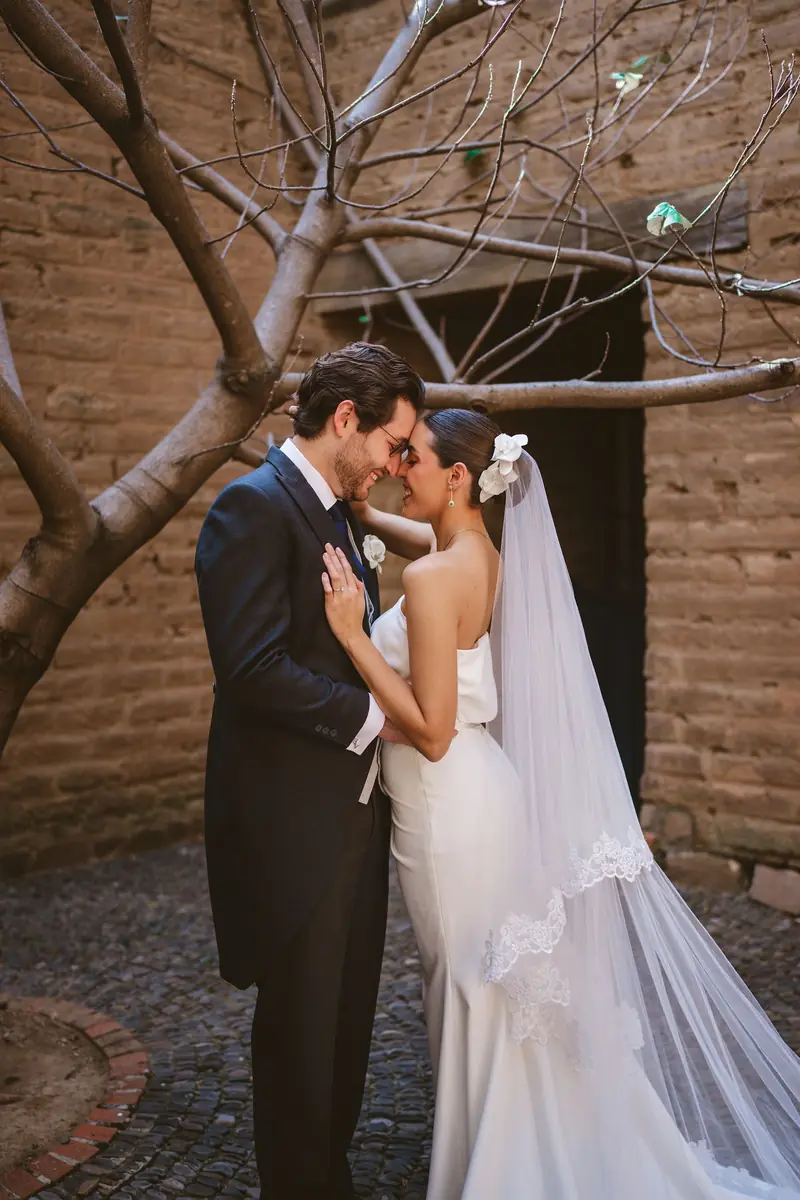 Bride and groom embracing in a stone courtyard, Mexico — Lemus Weddings
